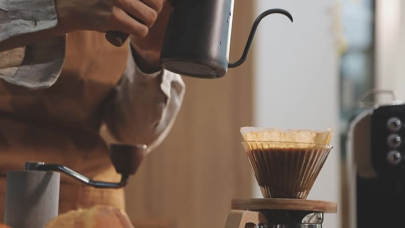 A barista pours hot water over a fresh pour-over coffee — a taste of what's brewing at Kayla's Kafe